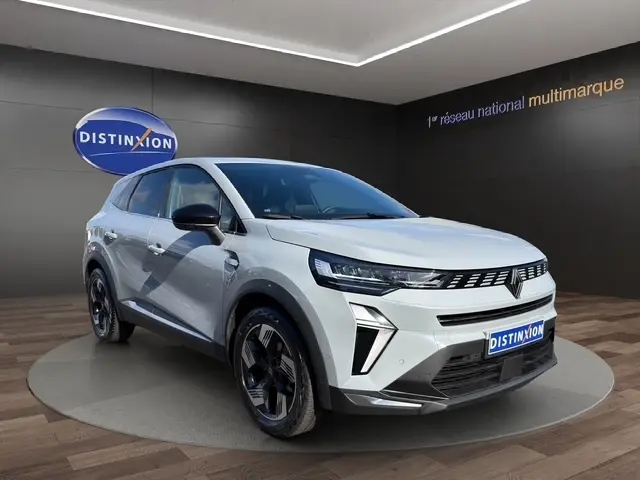 Vue 3/4 avant d'une Renault Symbioz gris clair avec détails noirs et jantes noires dans un showroom.