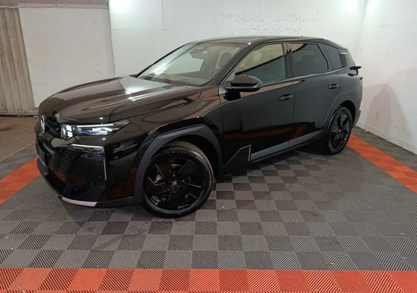 Vue 3/4 avant droite d'un Citroën C5 hybride noir avec jantes noires et lignes anguleuses modernes.