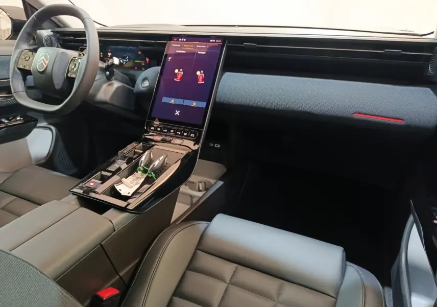 Vue intérieure de la Citroën C5 hybride 2026, tableau de bord moderne avec écran tactile vertical et volant multifonctions.