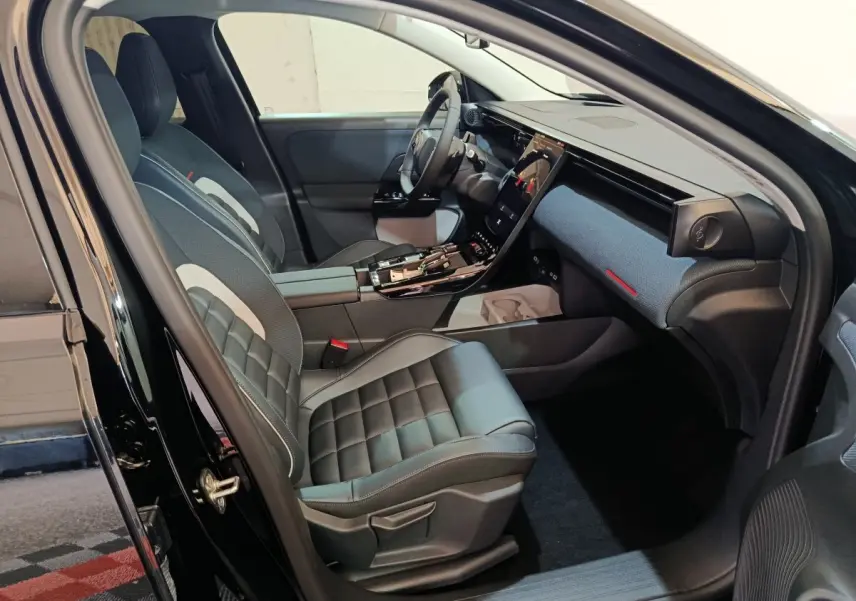 Intérieur avant droit de la Citroën C5 Hybride noire, avec sièges cuir et grand écran tactile central incliné.