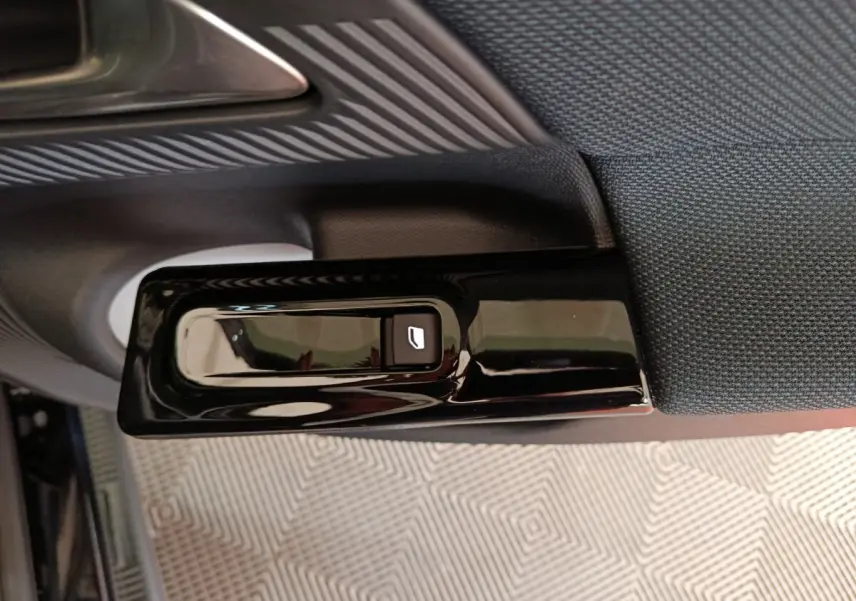 Détail de la commande électrique de lève-vitre côté gauche intérieur d’une Citroën C5 hybride noire 2026.
