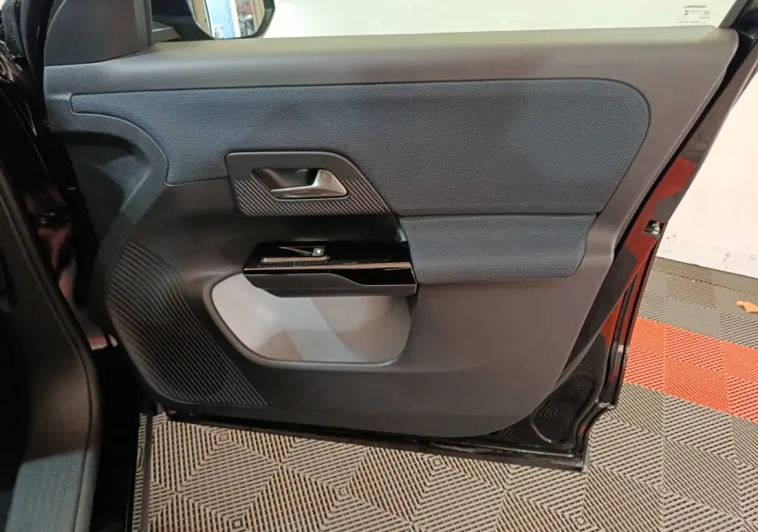 Vue intérieure de la porte arrière droite noire du Citroën C5 Hybride 2026, avec commande de fenêtre et garniture textile.