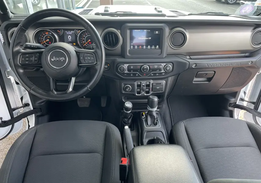 Vue intérieure frontale du tableau de bord noir du Jeep Wrangler 2018 avec volant multifonction et écran tactile central.