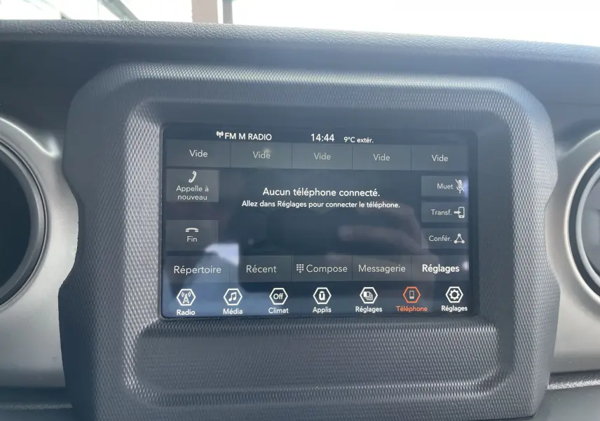 Écran tactile central du tableau de bord du Jeep Wrangler blanc 2018, affichant le menu téléphone sans connexion active.