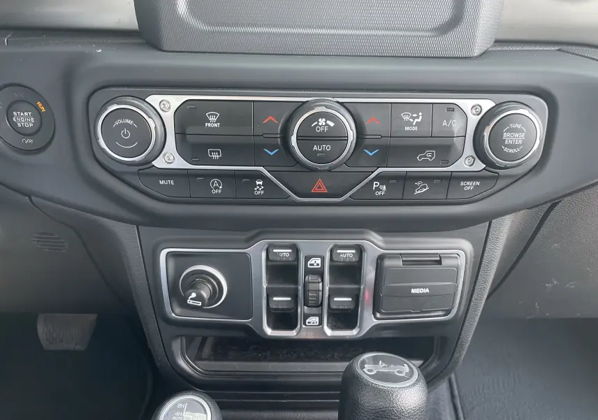 Vue rapprochée du tableau de bord noir et gris du Jeep Wrangler 2018 avec commandes climatisation et média.