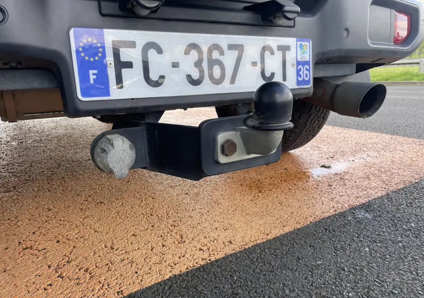 Gros plan sur l'attelage et la plaque arrière blanche d'un Jeep Wrangler 2018, avec sortie d'échappement visible à droite.