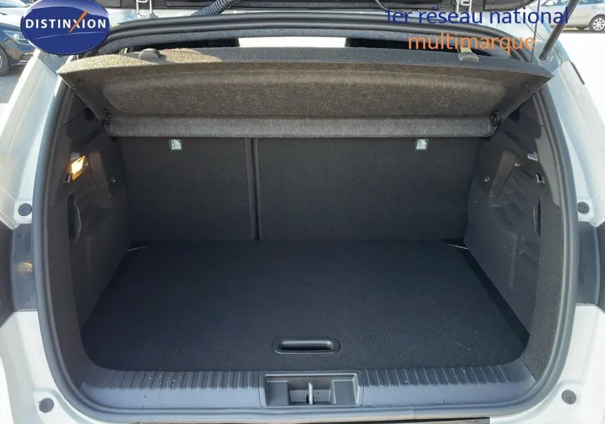 Coffre ouvert d'un Renault Captur blanc nacré avec toit gris, vue arrière montrant l'espace de chargement vide.