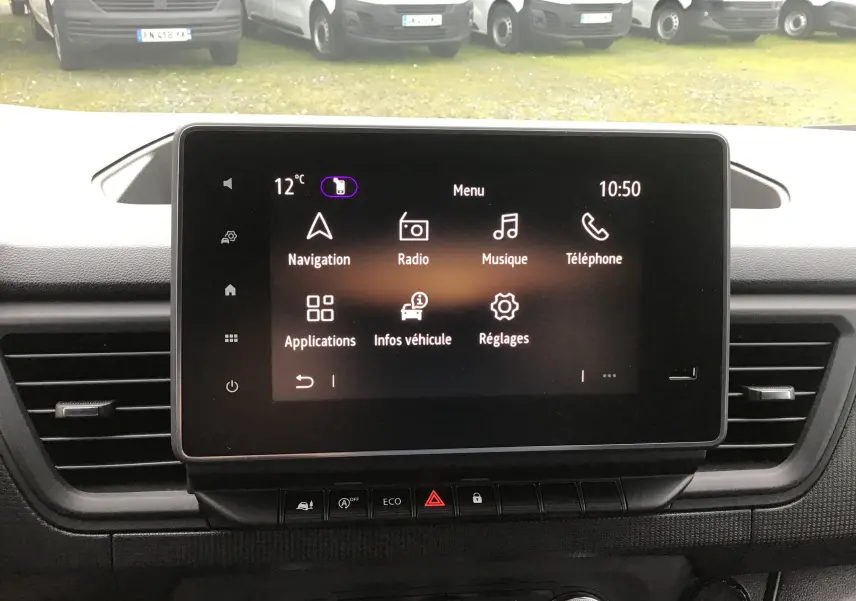 Vue rapprochée de l'écran tactile central du Renault Trafic Fourgon noir, affichant le menu multimédia avec navigation et radio.