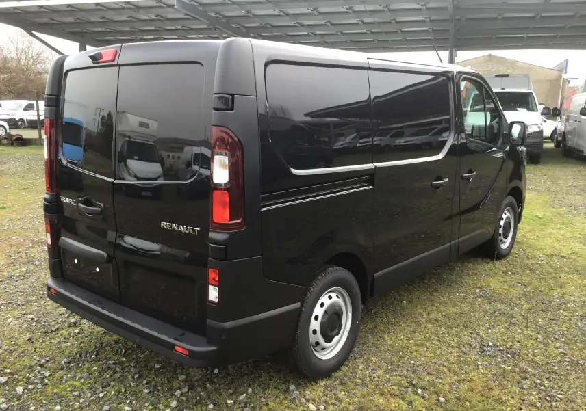 Vue 3/4 arrière droite du Renault Trafic Fourgon noir, mettant en valeur ses portes arrière battantes et ses feux verticaux.