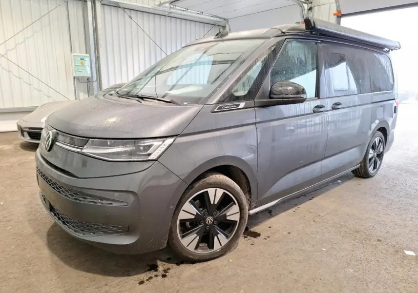 Vue 3/4 avant droit du Volkswagen California T7 2.0 TDI 150 DSG Ocean gris Indium avec jantes alliage noires brillantes.