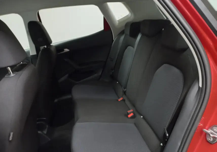 Vue intérieure du siège arrière côté droit d'un SEAT Arona rouge Désir avec toit noir, montrant les sièges en tissu noir.