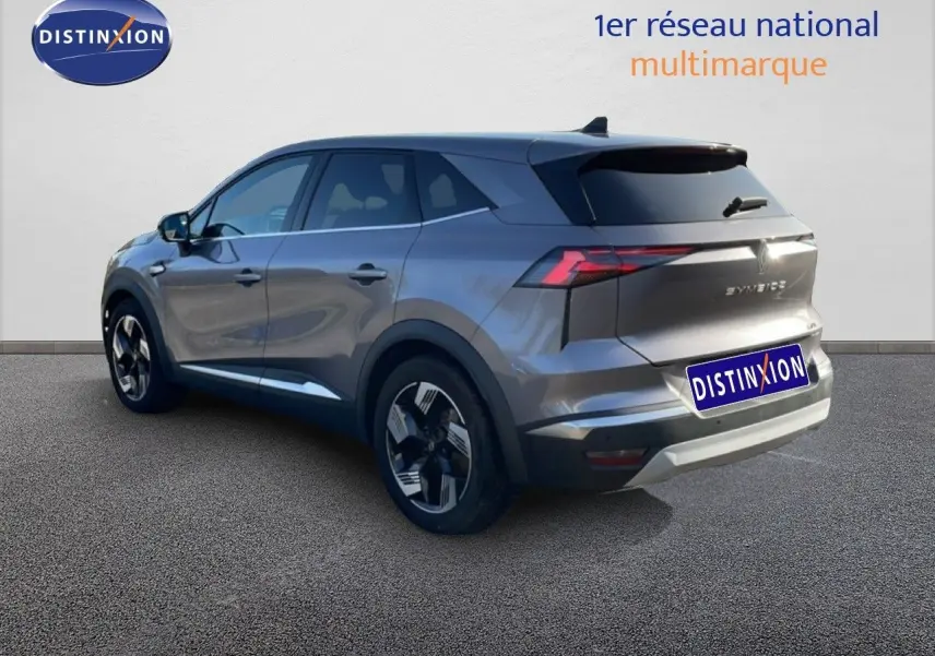 Vue 3/4 arrière droite du Renault Symbioz gris cassiopée métallisé, soulignant ses feux LED et ses jantes distinctives.
