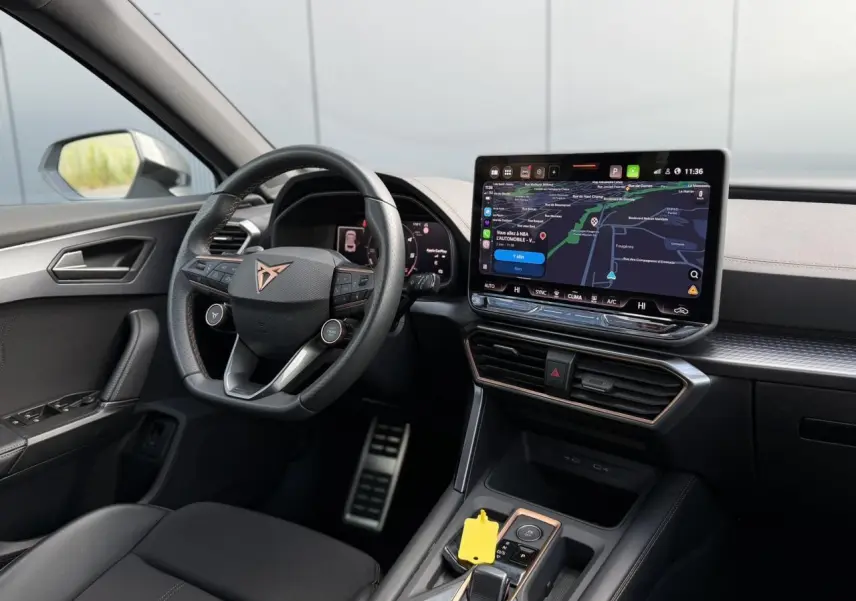 Vue intérieure côté conducteur du CUPRA Formentor 2025, volant cuir noir avec logo cuivre et écran tactile central.