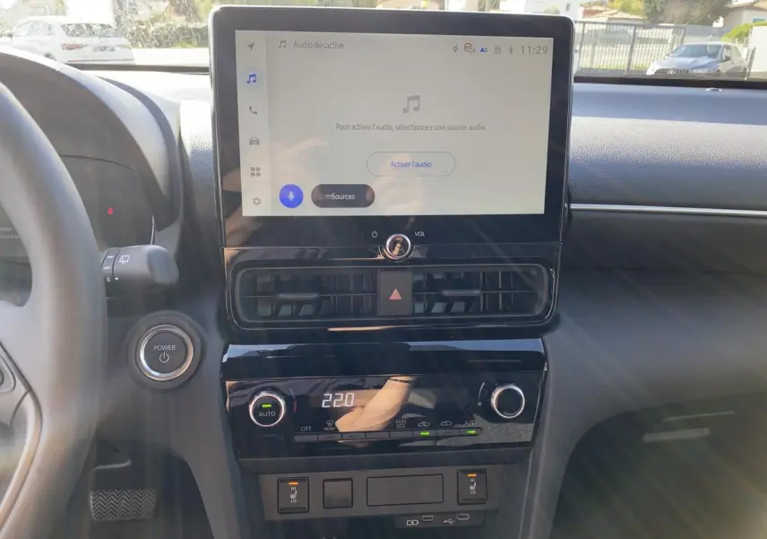 Vue rapprochée du tableau de bord de la Toyota Yaris Cross 2025 avec écran tactile et commandes climatisation.