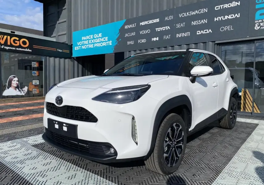 Toyota Yaris Cross blanc pur vue 3/4 avant droit avec jantes alliage noires et toit noir contrasté.