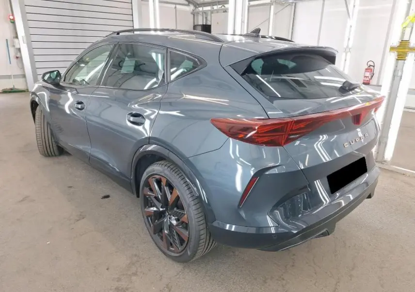 Vue 3/4 arrière droite d'une CUPRA Formentor gris magnétique avec jantes cuivrées et feux arrière en bandeau lumineux