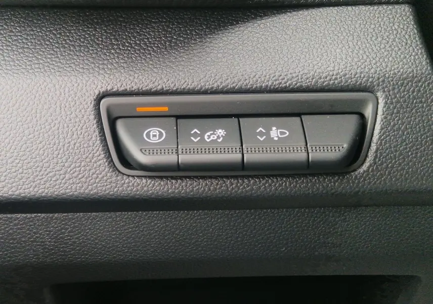 Boutons de réglage de la luminosité et des phares sur la planche de bord noire du Renault Trafic Fourgon gris urbain 2025.