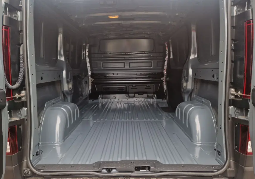 Vue arrière du fourgon Renault Trafic L1H1 gris urbain, montrant l’espace de chargement vide et métallique.