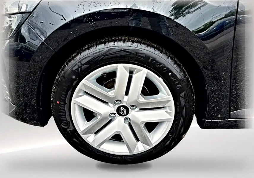 Gros plan sur la roue avant droite de la Renault Clio V noire, mettant en valeur la jante en alliage argentée et le logo Renault.