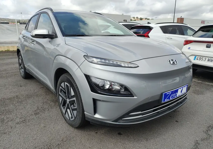 Vue 3/4 avant gauche d'un Hyundai Kona électrique gris métallisé avec jantes alliage et calandre lisse.