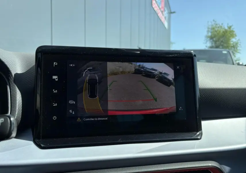 Écran tactile intérieur montrant la caméra de recul du SEAT Arona Rouge Désir avec lignes de guidage vertes et rouges.