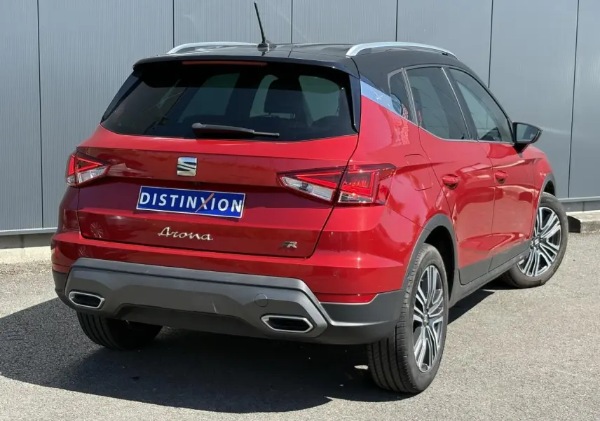 Vue 3/4 arrière droite d'un SEAT Arona TSI 110 FR rouge Désir avec toit noir et jantes alliage 17 pouces.