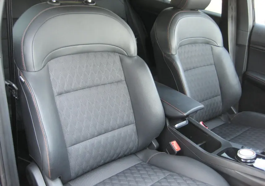 Gros plan sur les sièges avant en cuir noir avec surpiqûres orange de la MG3 1.5 HYBRID+ 2024.