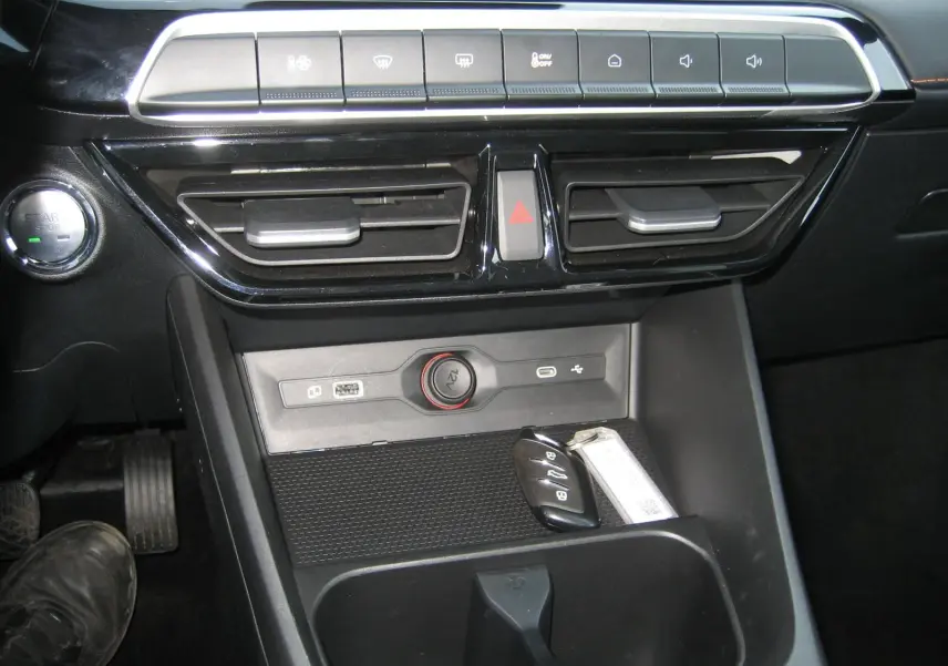 Vue rapprochée de la console centrale noire du MG3 2024 avec boutons de commande, prise 12V et clé posée.