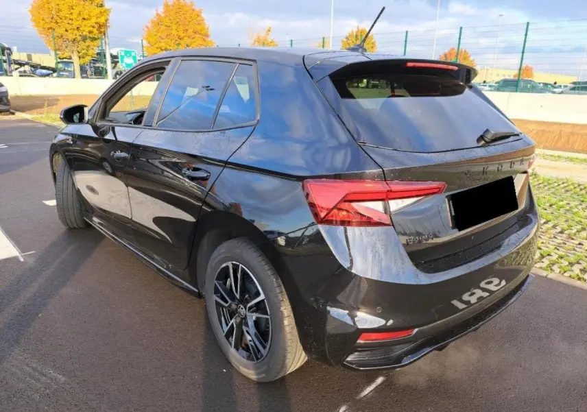 Vue 3/4 arrière gauche d'une Skoda Fabia Monte Carlo 2024 en noir Magic avec jantes noires et feux arrière LED.