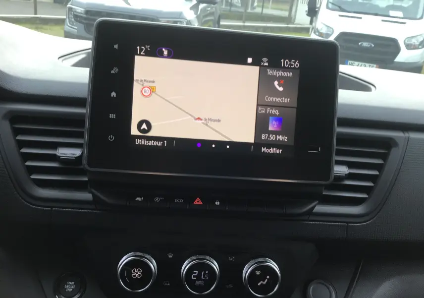 Vue intérieure du tableau de bord du Renault Trafic Fourgon 2025 avec écran tactile affichant la navigation et commandes de climatisation.