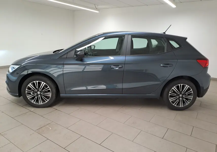 Profil droit d'une SEAT Ibiza 1.0 TSI 115 DSG7 Copa gris magnétique, avec jantes alliage et intérieur visible.