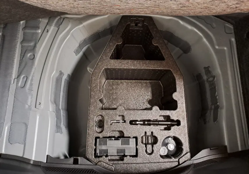 Vue du compartiment de rangement sous le coffre de la SEAT IBIZA 1.0 TSI 115 DSG7 COPA 2025, sans accessoires visibles.