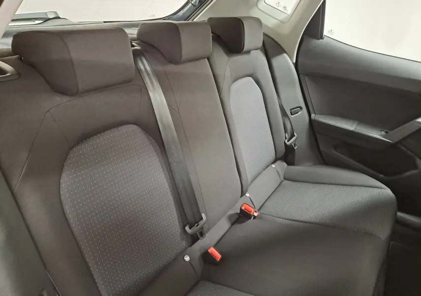 Vue intérieure de la banquette arrière du SEAT Ibiza 2025, sièges en tissu gris foncé avec ceintures de sécurité visibles.