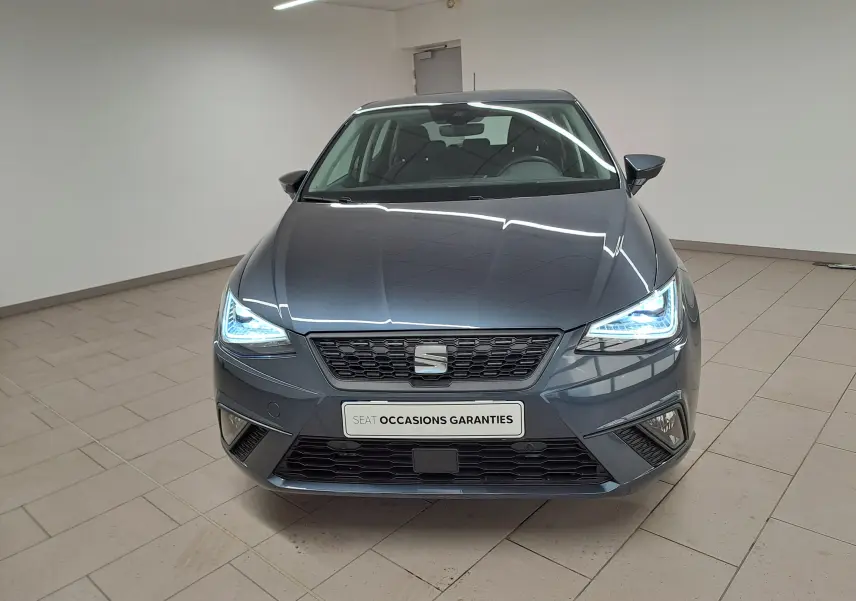 Vue frontale d'une SEAT Ibiza 1.0 TSI 115 DSG7 Copa gris magnétique avec phares LED allumés en intérieur.