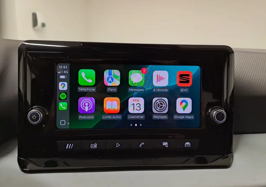 Écran tactile central allumé de la SEAT Ibiza 2025, affichant les applications connectées, entouré de boutons noirs brillants.