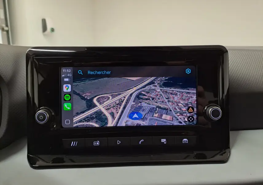 Écran tactile central de la SEAT Ibiza 2025 affichant une carte GPS en vue satellite, entouré de commandes noires brillantes.