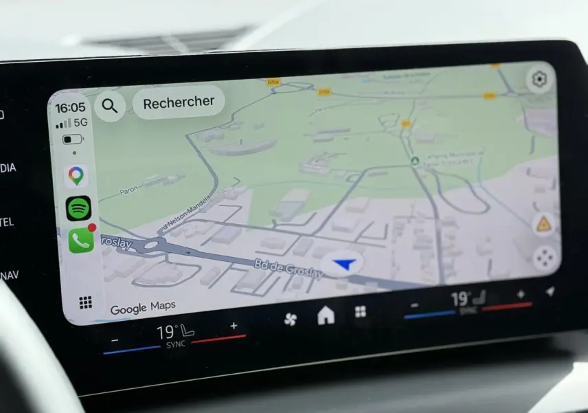 Écran tactile BMW Curved Display affichant la navigation Google Maps et commandes climatisation bi-zone.