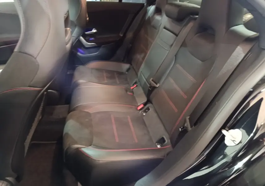 Vue intérieure côté droit des sièges arrière noirs avec surpiqûres rouges de la Mercedes CLA 200 d AMG Line 2022.