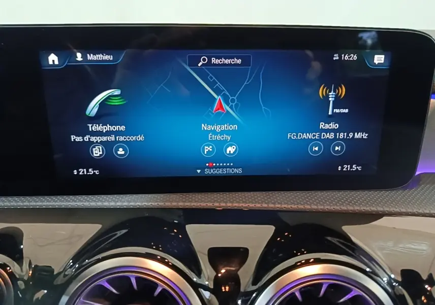 Écran tactile central du tableau de bord avec navigation, téléphone et radio dans une Mercedes CLA 200 d AMG Line noire.