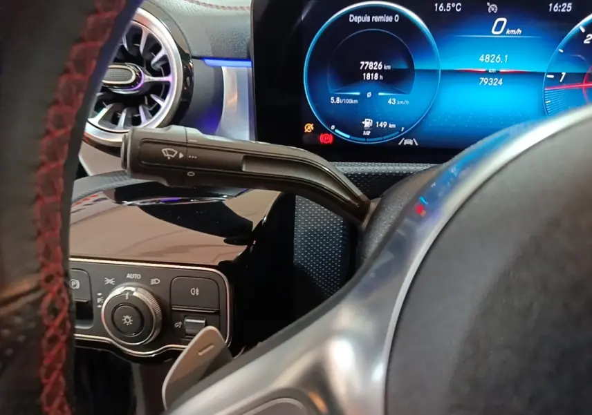 Gros plan intérieur sur le volant noir et le tableau de bord numérique bleu d'une Mercedes CLA 200 d AMG Line 2022.