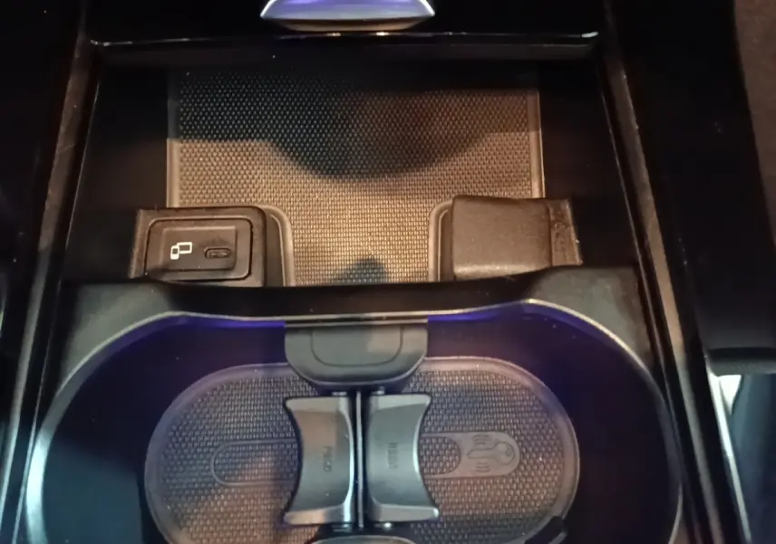 Gros plan sur le porte-gobelets et prise USB du compartiment central intérieur noir de la Mercedes CLA 200 d AMG Line 2022.