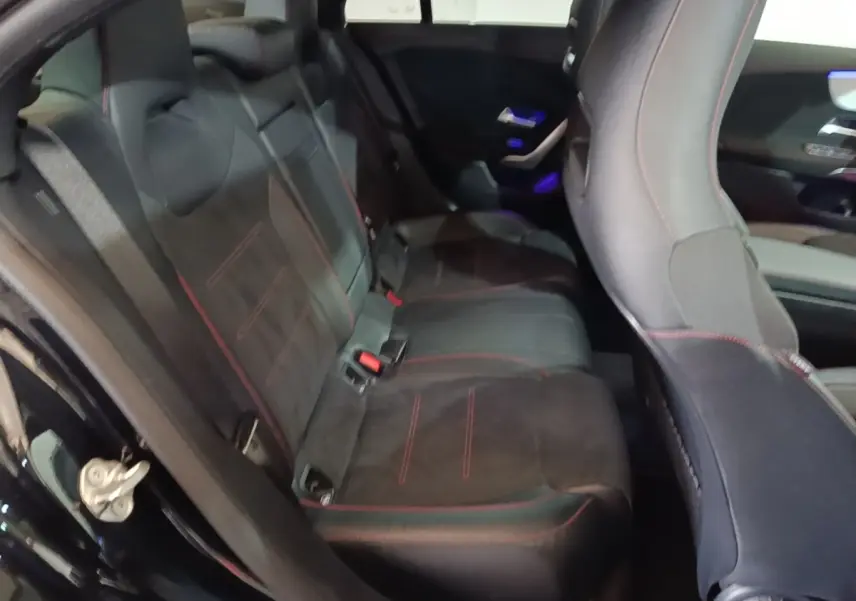 Vue intérieure côté arrière gauche de la banquette noire avec surpiqûres rouges du Mercedes CLA 200 d AMG Line 2022.