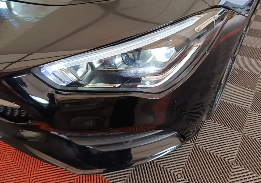 Gros plan sur le phare avant droit noir brillant d'une Mercedes CLA 200 d AMG Line 2022, détails LED visibles.