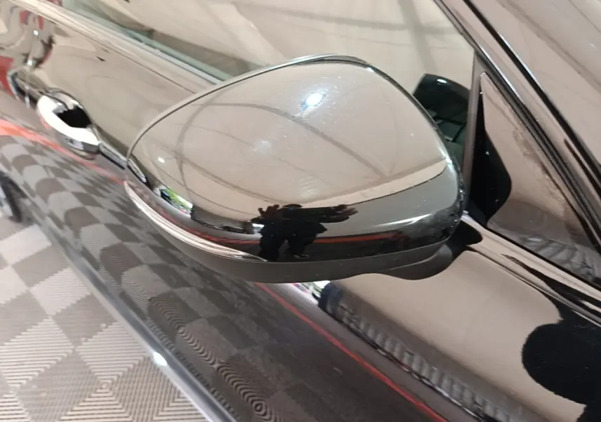Gros plan sur le rétroviseur côté gauche noir brillant d'une Mercedes CLA 200 d AMG Line 2022.