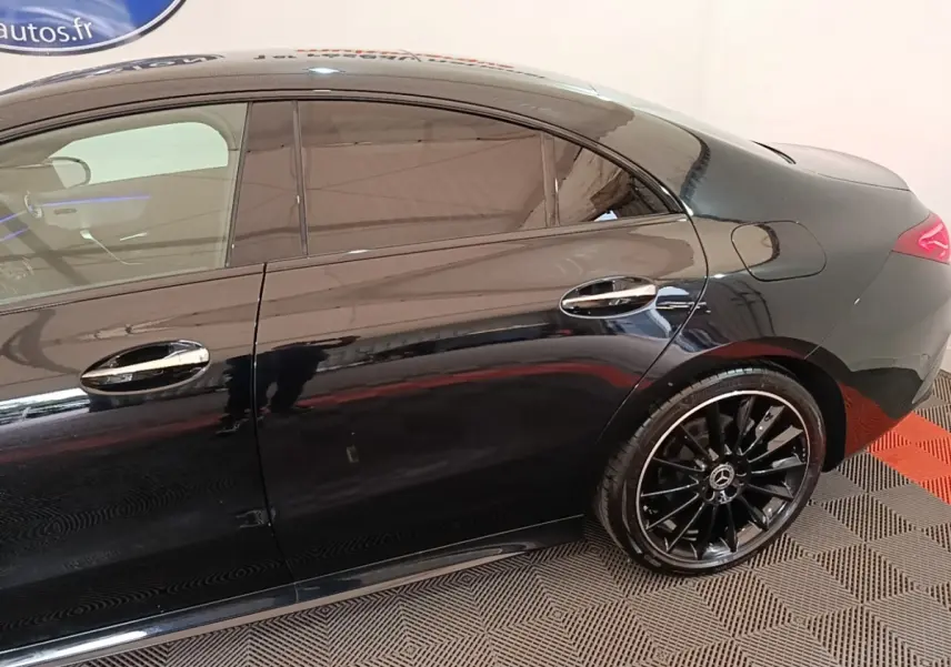 Vue latérale droite d'une Mercedes CLA 200 d AMG Line noire avec jantes alliage noires et vitres teintées.