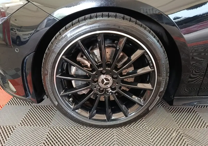 Gros plan sur la roue avant gauche noire à jante AMG brillante d'une Mercedes CLA 200 d AMG Line 2022.