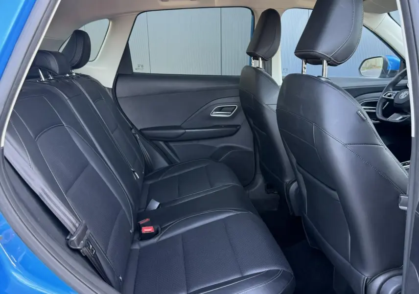 Vue intérieure arrière du MG ZS 1.5 Hybrid+ 197 Luxury bleu Como, sièges tissu/similicuir noirs et banquette 3 places.