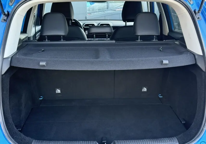 Coffre ouvert d’un MG Motor ZS 1.5 Hybrid+ 197 Luxury bleu Como, vue arrière montrant l’espace de chargement et les sièges noirs.