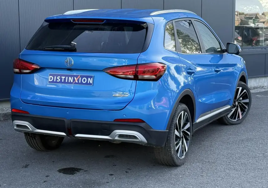 Vue 3/4 arrière droite du MG ZS 1.5 Hybrid+ 197 Luxury bleu Como avec jantes alliage et vitres surteintées.