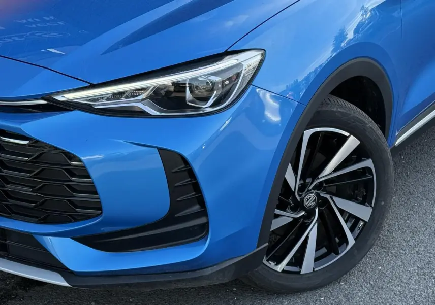 Gros plan sur l'avant droit bleu Como du MG ZS 1.5 Hybrid+ 197 Luxury, avec phares LED et jantes alliage noires et argentées.